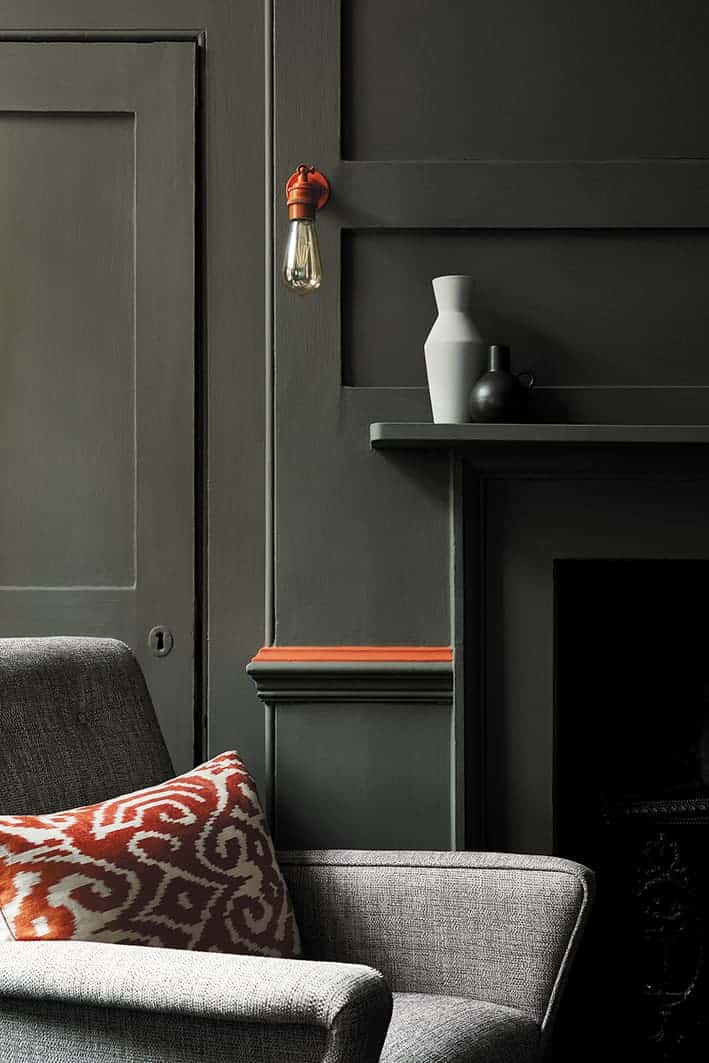 love these dark green walls and fireplace in living room with pop of orange by Little Greene. Click through for more green paint colours you'll love