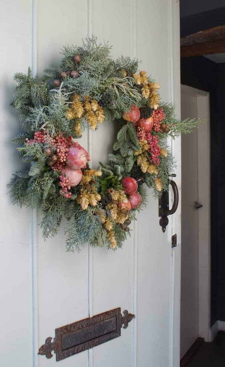 make a fresh christmas wreath like this one with hops, frosted fresh apples, pink peppercorns and frosted greenery. Click through for simple step by steps as well as lots of other ideas to inspire you this festive and holiday season #christmaswreath #wreath #flowers #tutorial #holiday